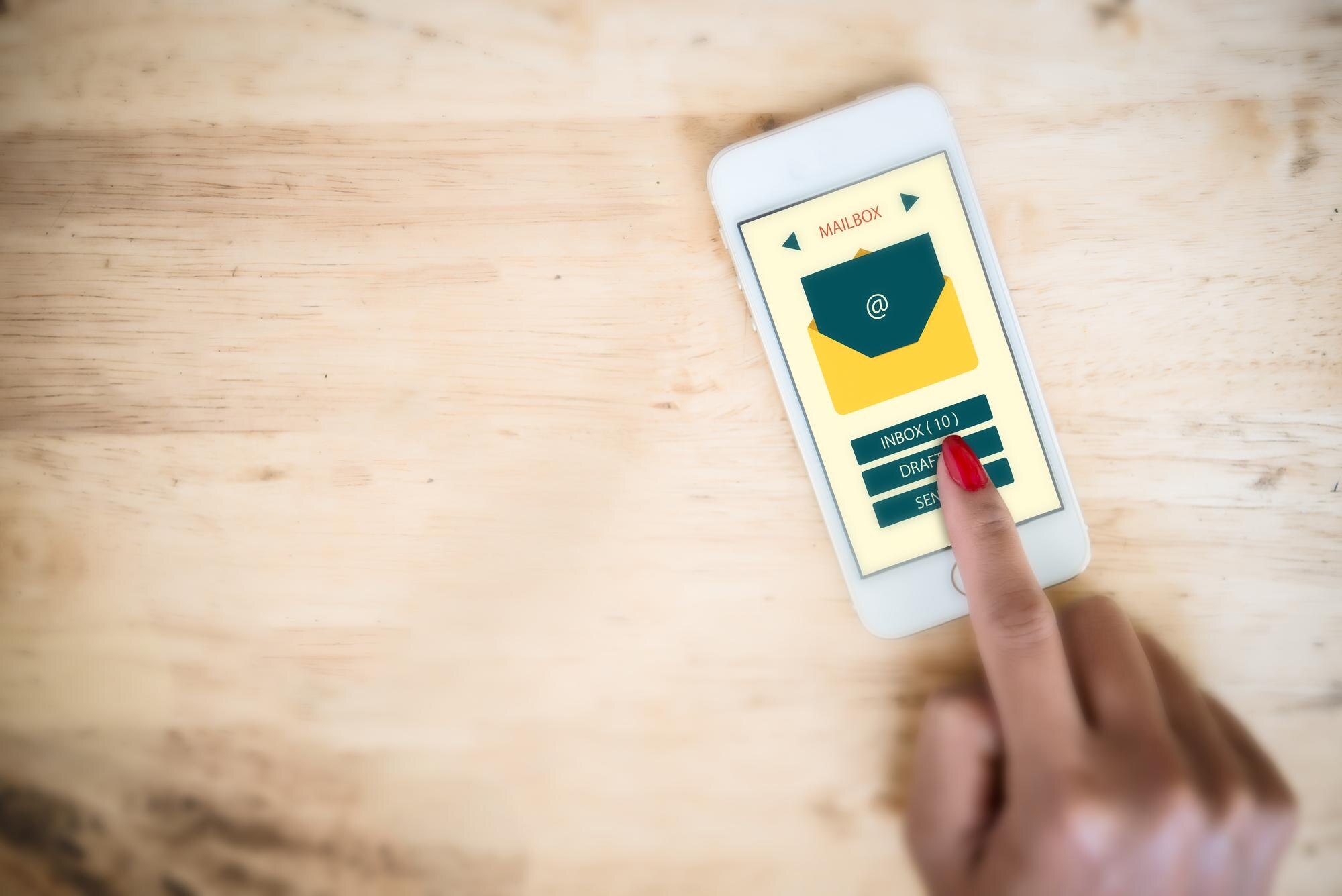 Zbliżenie kobiety używającej telefonu komórkowego na stole