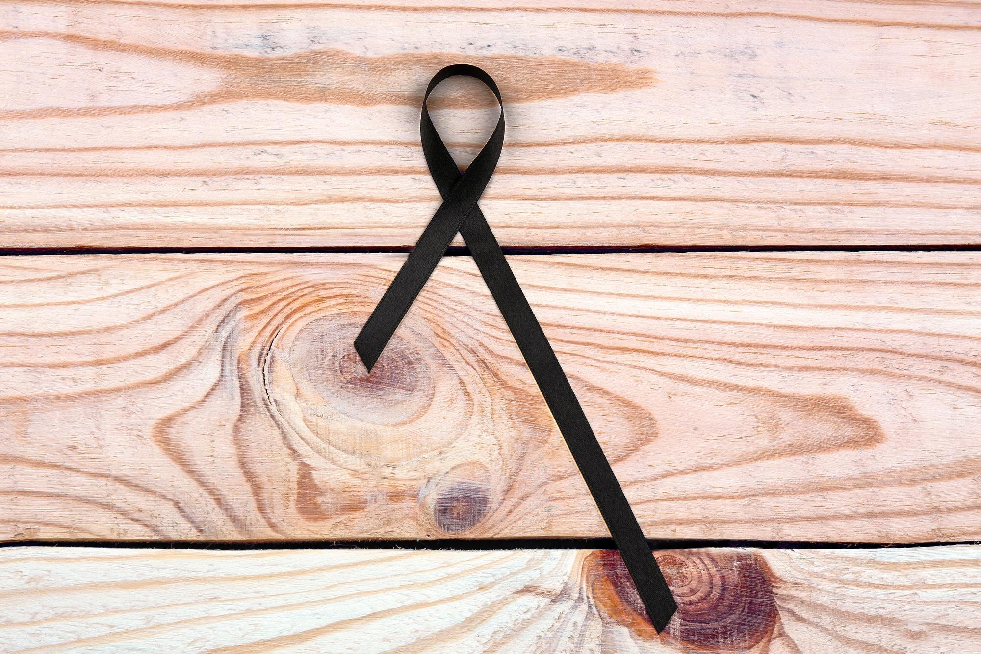 Czarna wstążka na drewnianym tle Melanoma i koncepcja żałoby