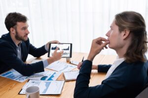 Zajęty zespół analityków w biurze analizujący analizę danych finansowych według tabletu Entity