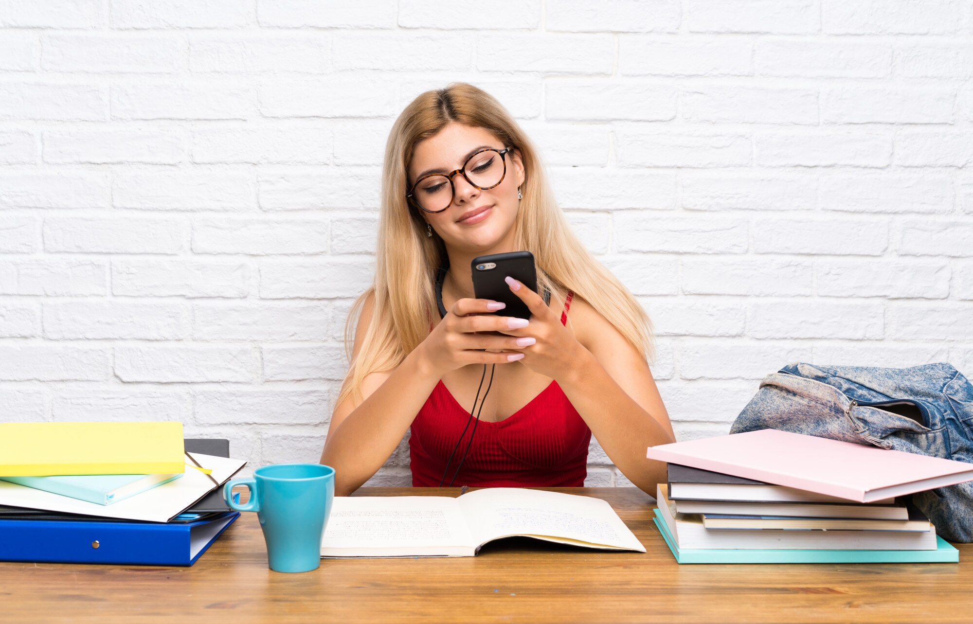 Nastolatek studencka dziewczyna przy indoors wysyła wiadomość z wiszącą ozdobą
