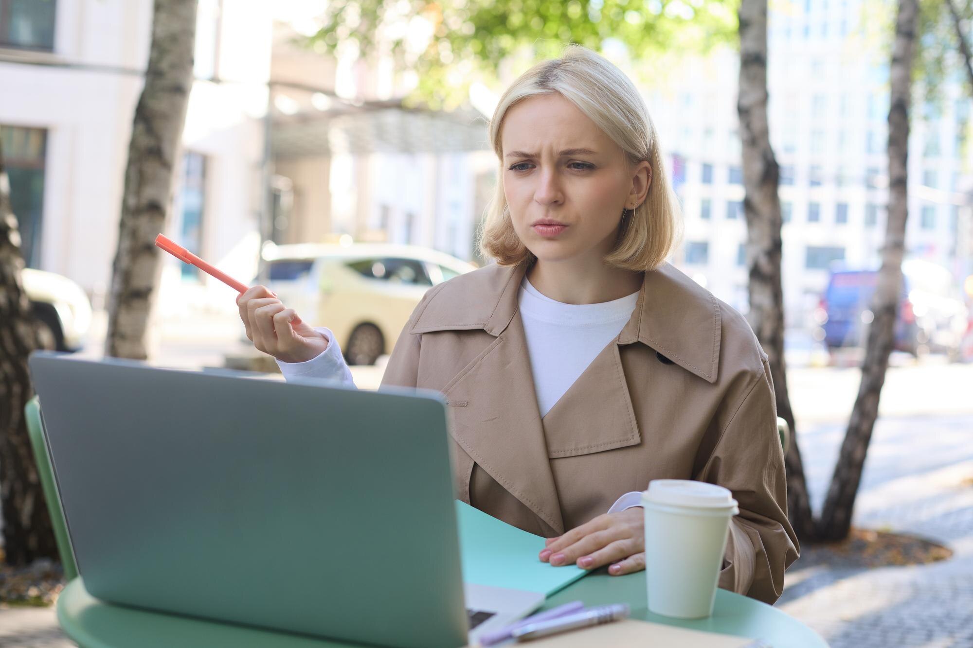 Obraz kobiety z zdezorientowaną twarzą patrzącej na laptopa pracującego zdalnie rozmawiającego z kimś i